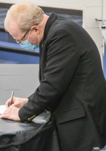 Professor writing on a notepad
